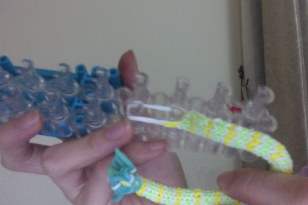 Then put all 6 bands onto the peg in front of the left peg. Tip: stretch them out 2 at a time. If you try to put all 6 on at the same time, you might end up breaking your hook or bands!