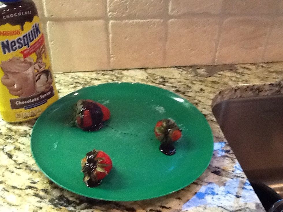 Then put the chocolate syrup on the three strawberries