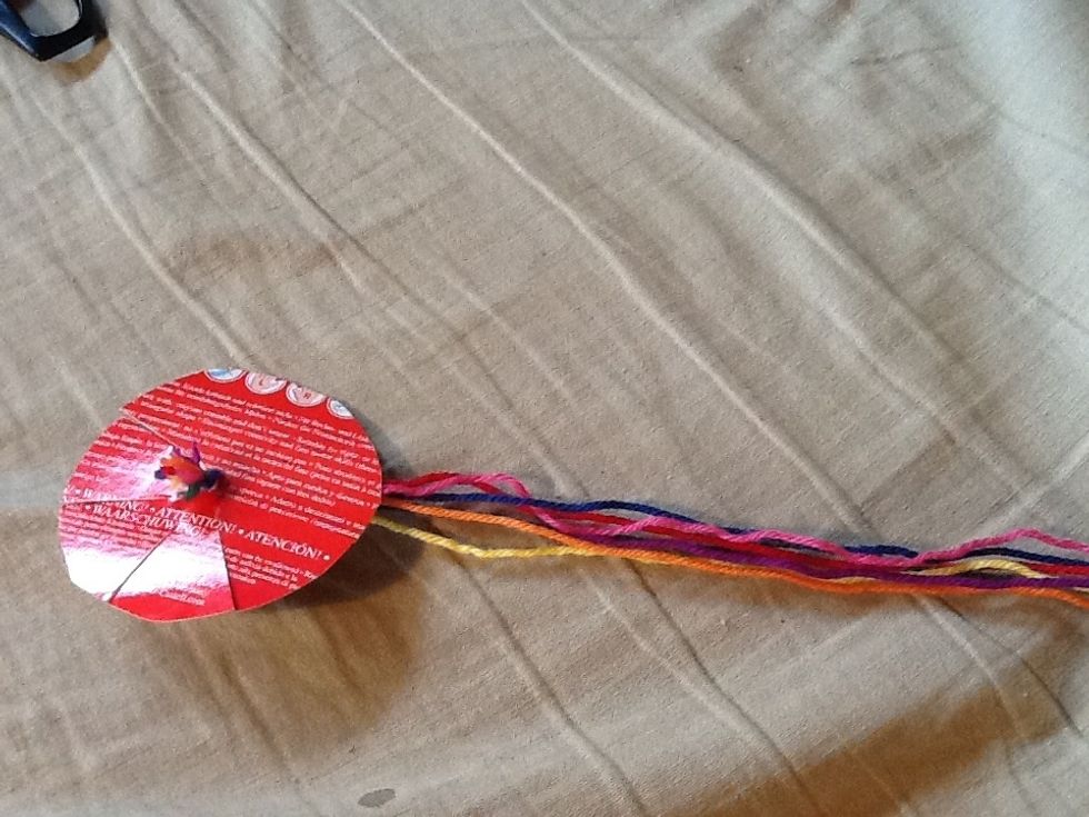 Then put the end With knot on it through the hole in the cartboard