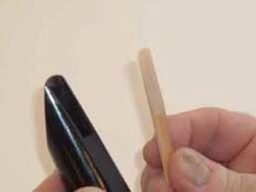 Then put the piece that looks like wood, it's called a reed. You want to put it on top of the hole that is on top of the mouthpiece