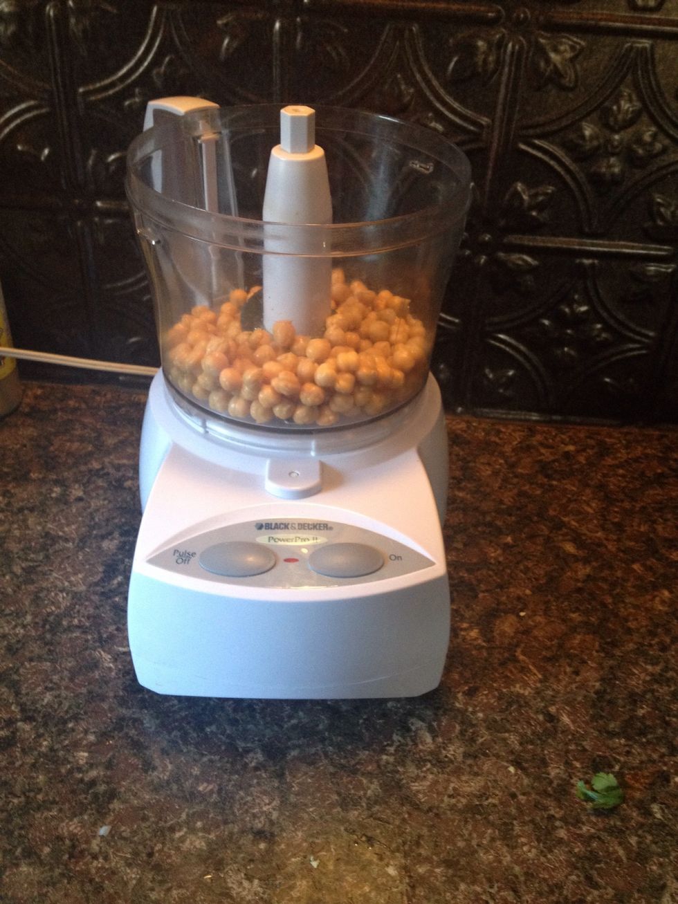 Then put the skinned chickpeas into your food processor and start it. They will need to stay in here about 30 seconds, or until they look like a fine grain