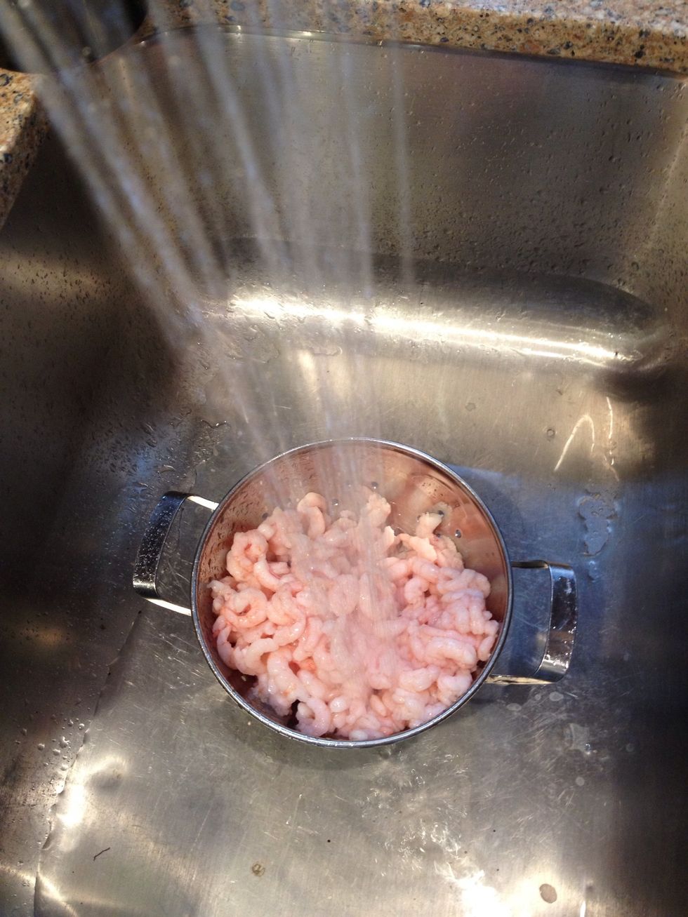 Then put your shrimps into a colander and rinse with cold water.