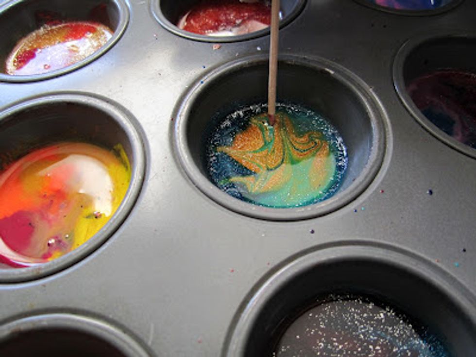 Then, quickly swirl designs with a toothpick to each of the melted crayons. It is better if you use a different toothpick for each hole. Then, let the crayons to cool for 12-15 minutes.