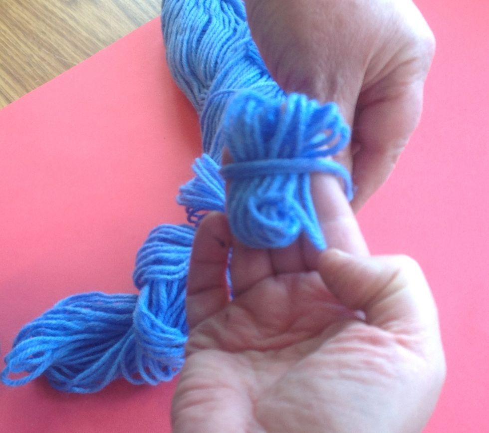 Then, remove the yarn and lay the 'loop' ALONG your fingers. Roll the yarn ACROSS the loop and around your fingers again. Until you have a ball that fits comfortably in your hand.