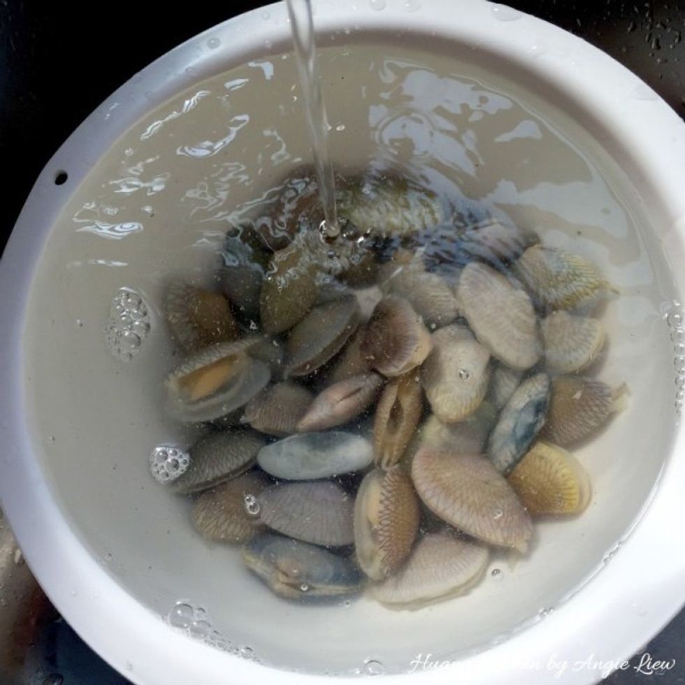 Then rinse under running water to remove mud trapped inside shells. Replace with fresh water. Continue to soak clams for another 20 mins. Repeat this process 3x to ensure clams are thoroughly cleaned.