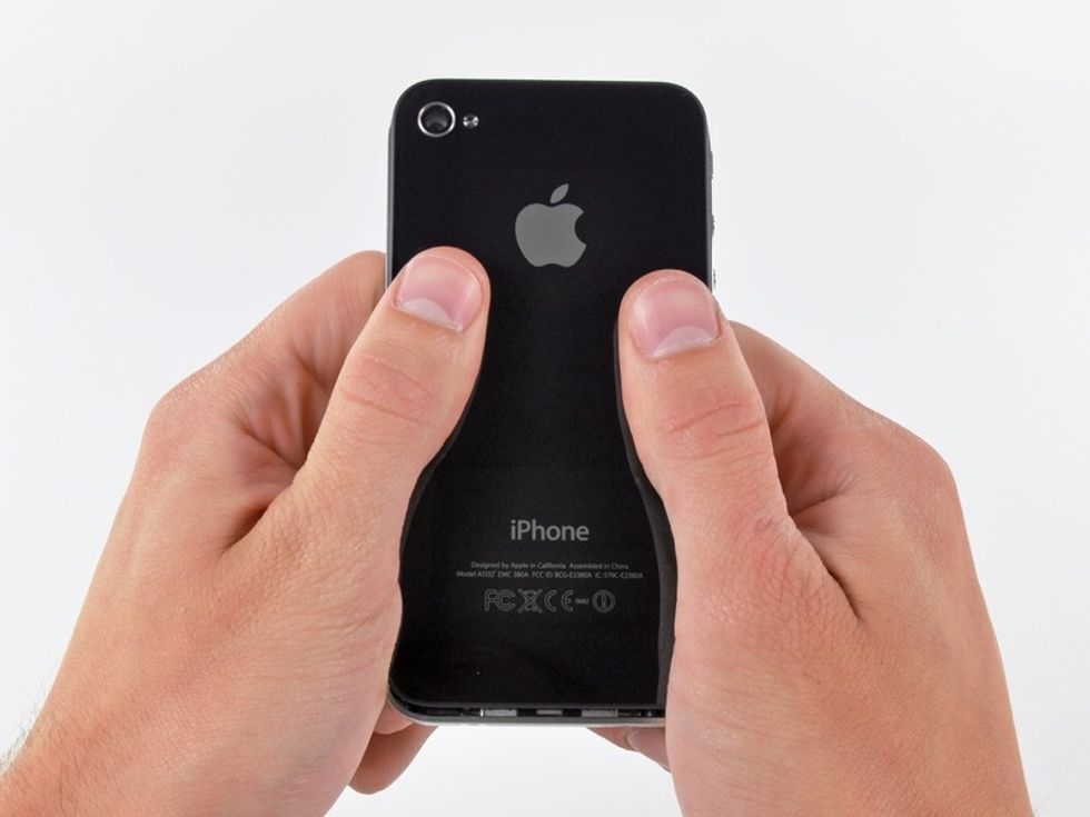 Then slide the back panel up. It'll click and only move a quarter inch or so (see bottom of iPhone to see how far it'll slide).