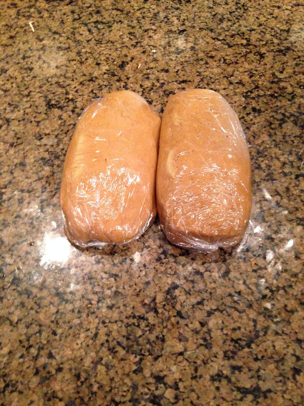 Then split the dough into 2 equal parts and wrap it in plastic wrap