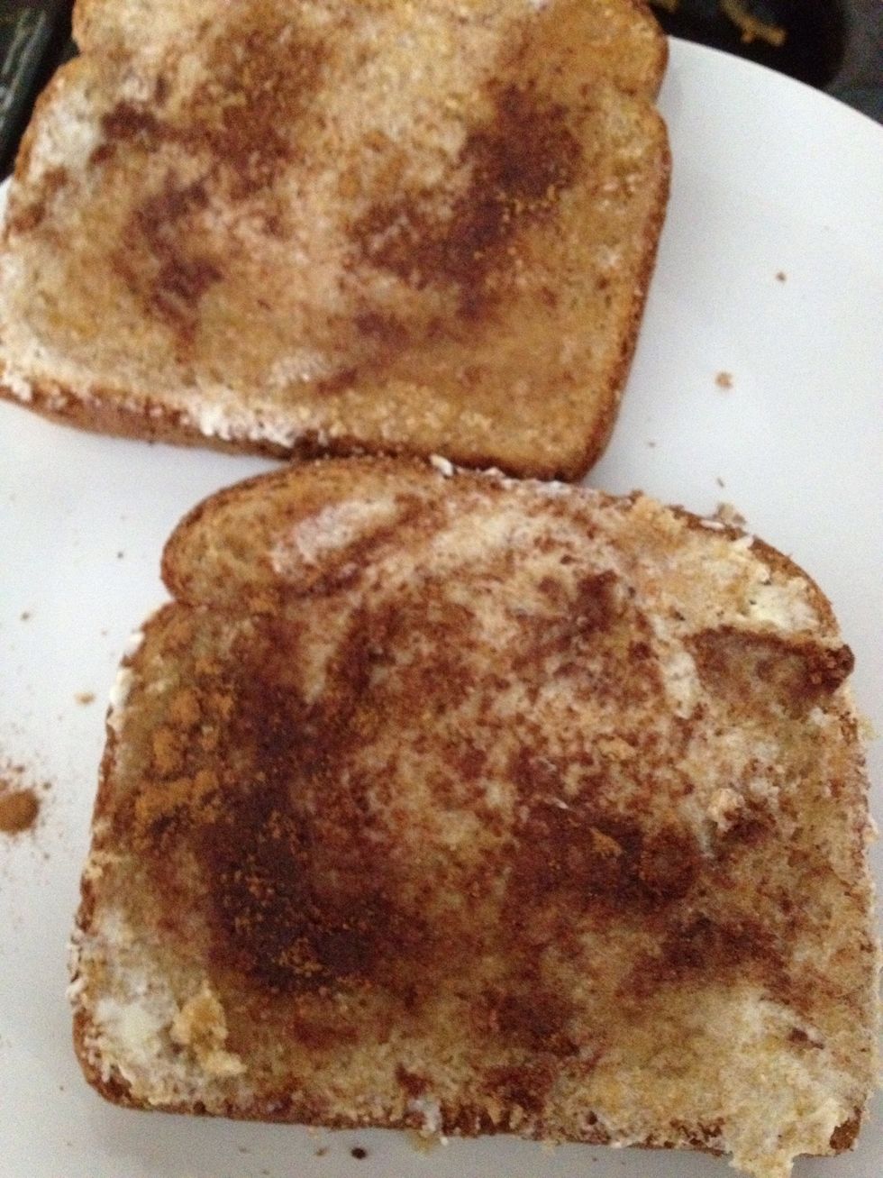 Then spread some brown sugar all over the toast lightly. Then sprinkle cinnamon on it. It you accidentally pour too much on it you can just spread it evenly on top too.