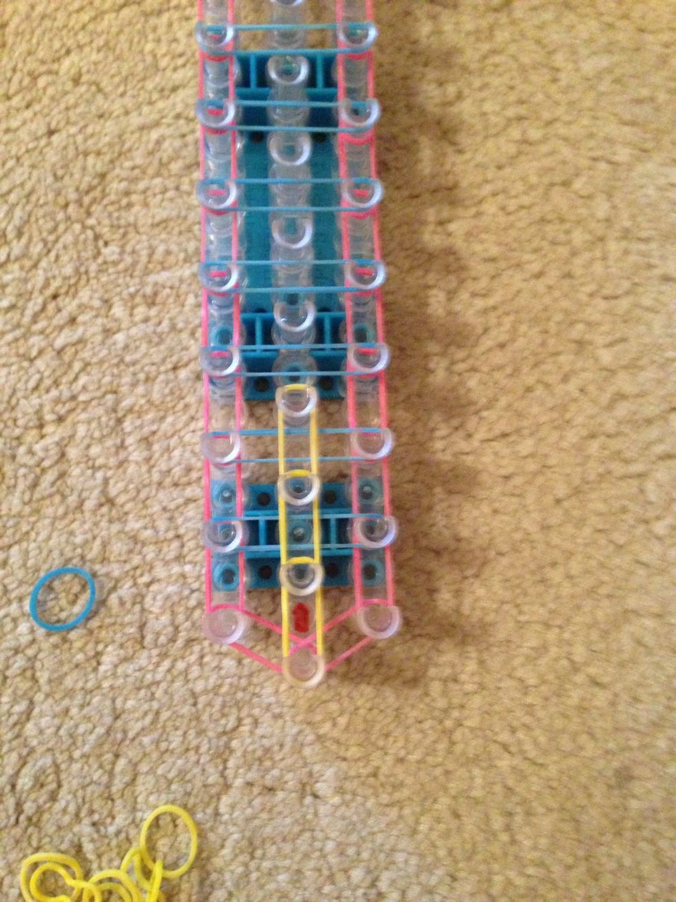 Then start adding another color band all down the center of the loom