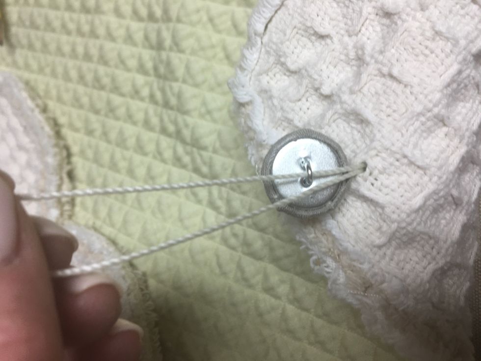 Then string the contrast button (gray) on the reverse side and tie in a knot.  Put a dab of hot glue on the knot and clip the strings close.