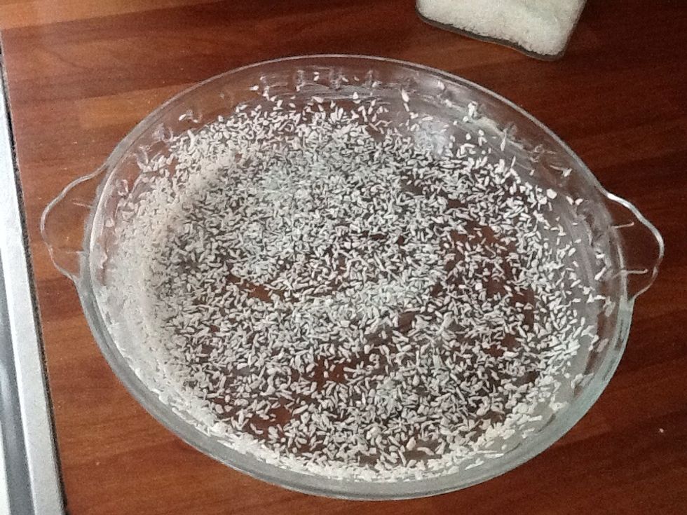 Then take a cake tin and butter it. When you've done that, you take the coconut or breadcrumbs and spread it all over.