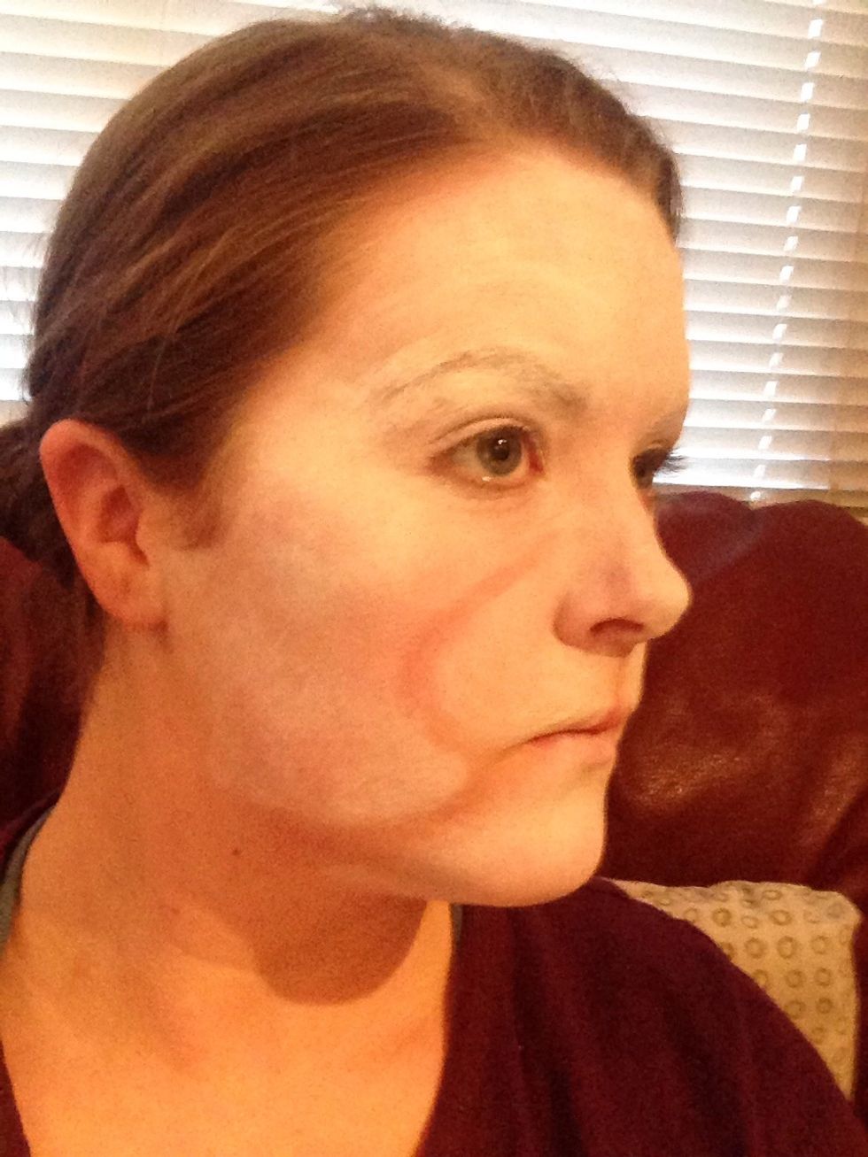 Then take a darker face paint or foundation and draw in the shapes you see on the picture on both sides of your face, and under your nose.