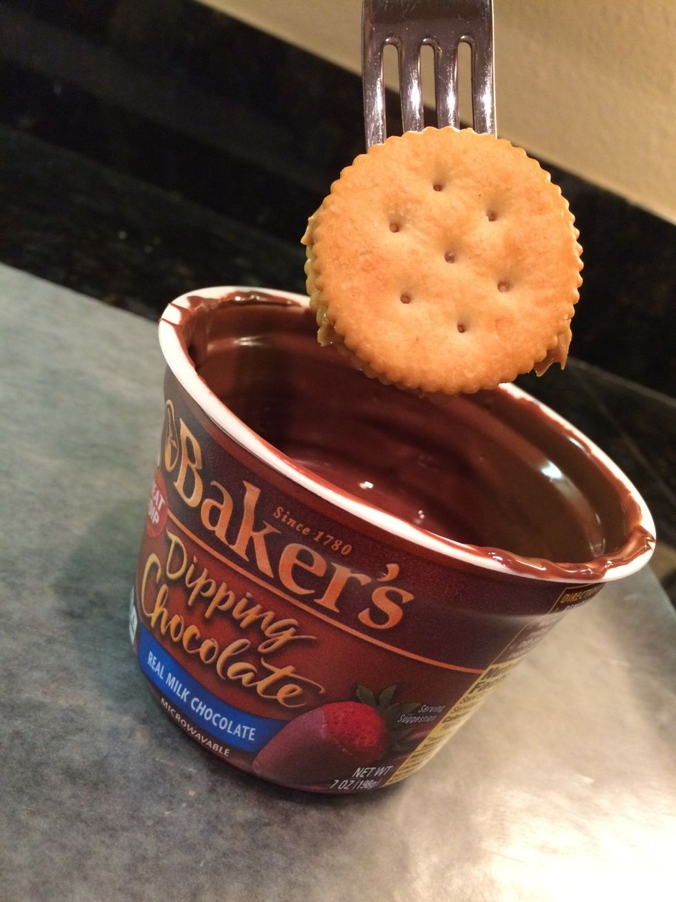 Then, take a fork put it between the crackers and dip it in the melted chocolate.