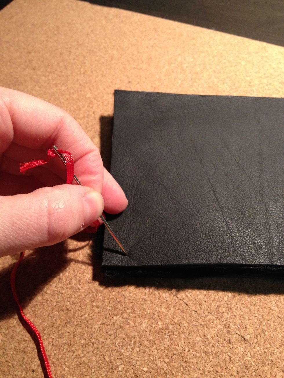 Then take a sewing needle, preferably a strong one, and make holes in the leather to mark where you'll be sewing the two leather pieces together to form the case.