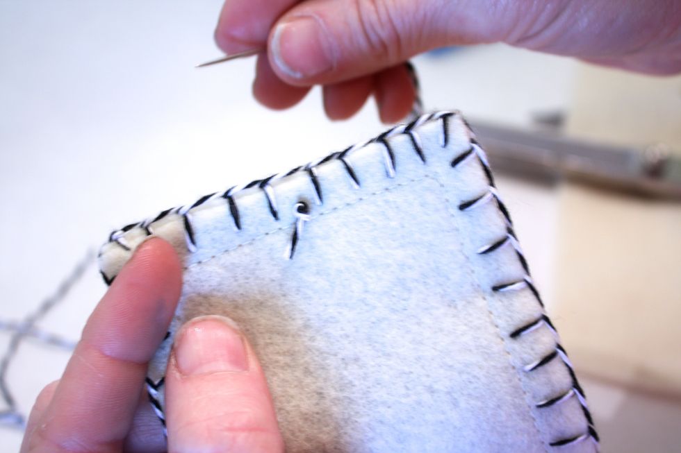 Then take about 10 inches of twine and make a double knot on the inside. Do one stitch in