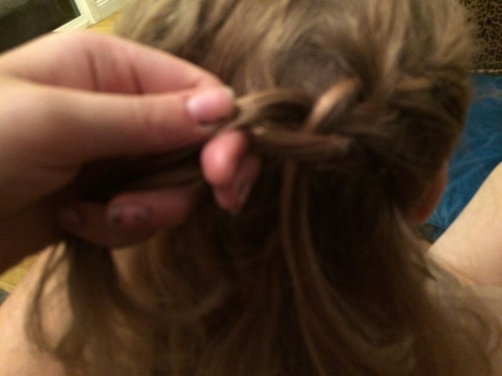 Then take another strand of hair and once you twist the strand of hair that is closest to the top of your head, drop it and use the strand you just picked up to replace it