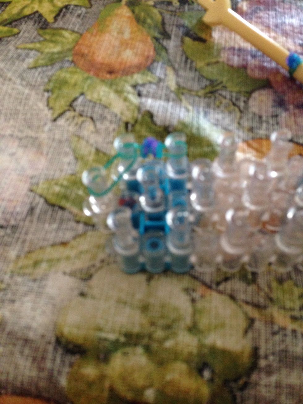 Then take one side of the bud and move it over to one peg