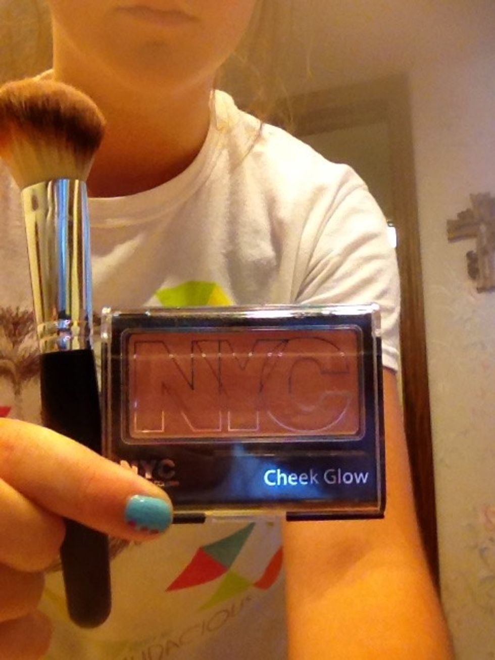 Then take your blush and apply it to the apples of your cheeks with your angled brush