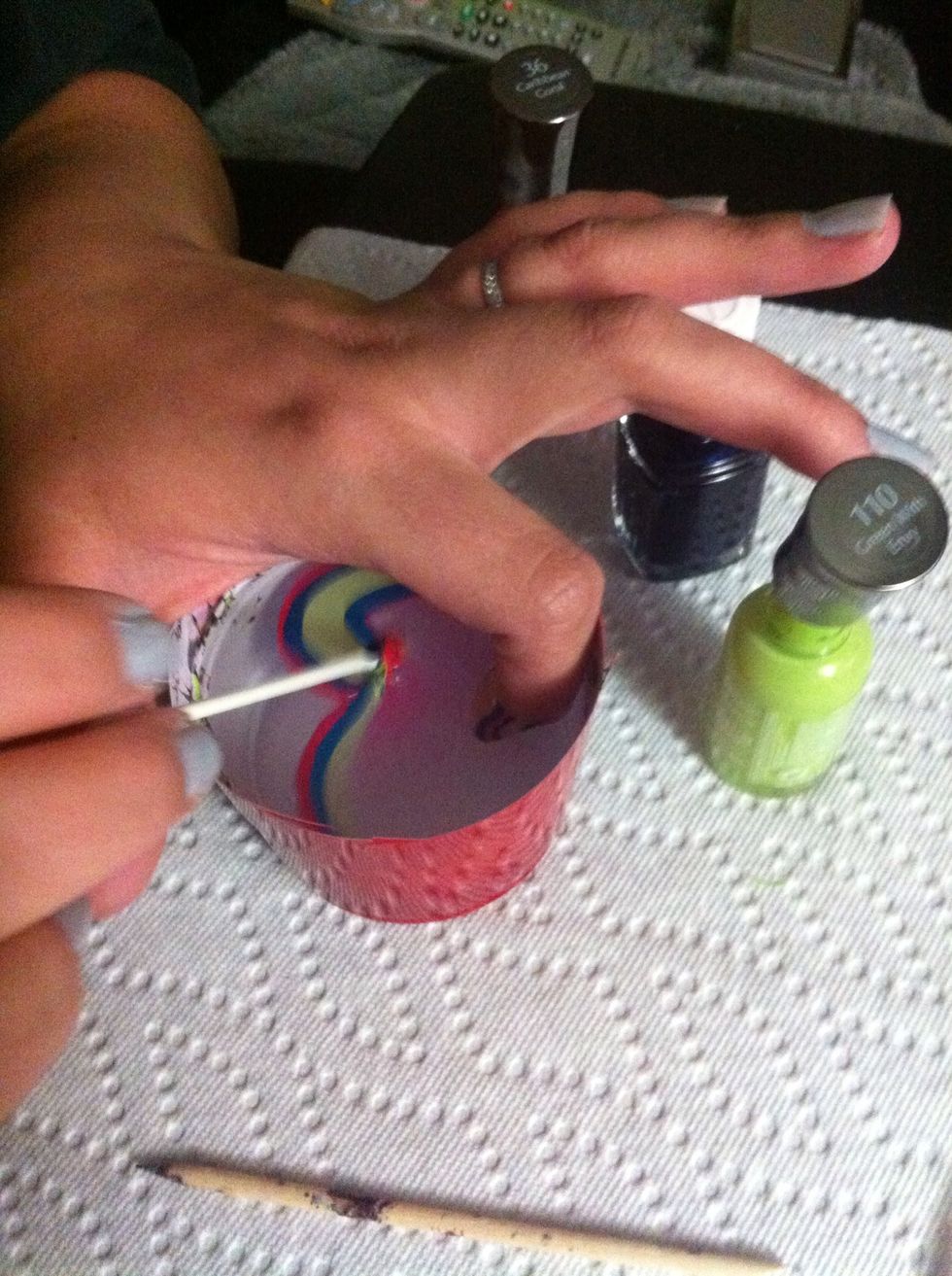 Then take your Q-tip and clean the nail polish around your finger.