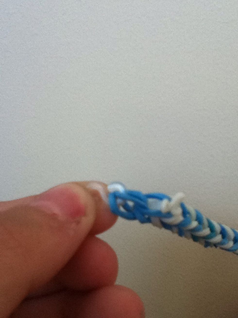 Then take your s clip and put the ends of the loom bands on one side