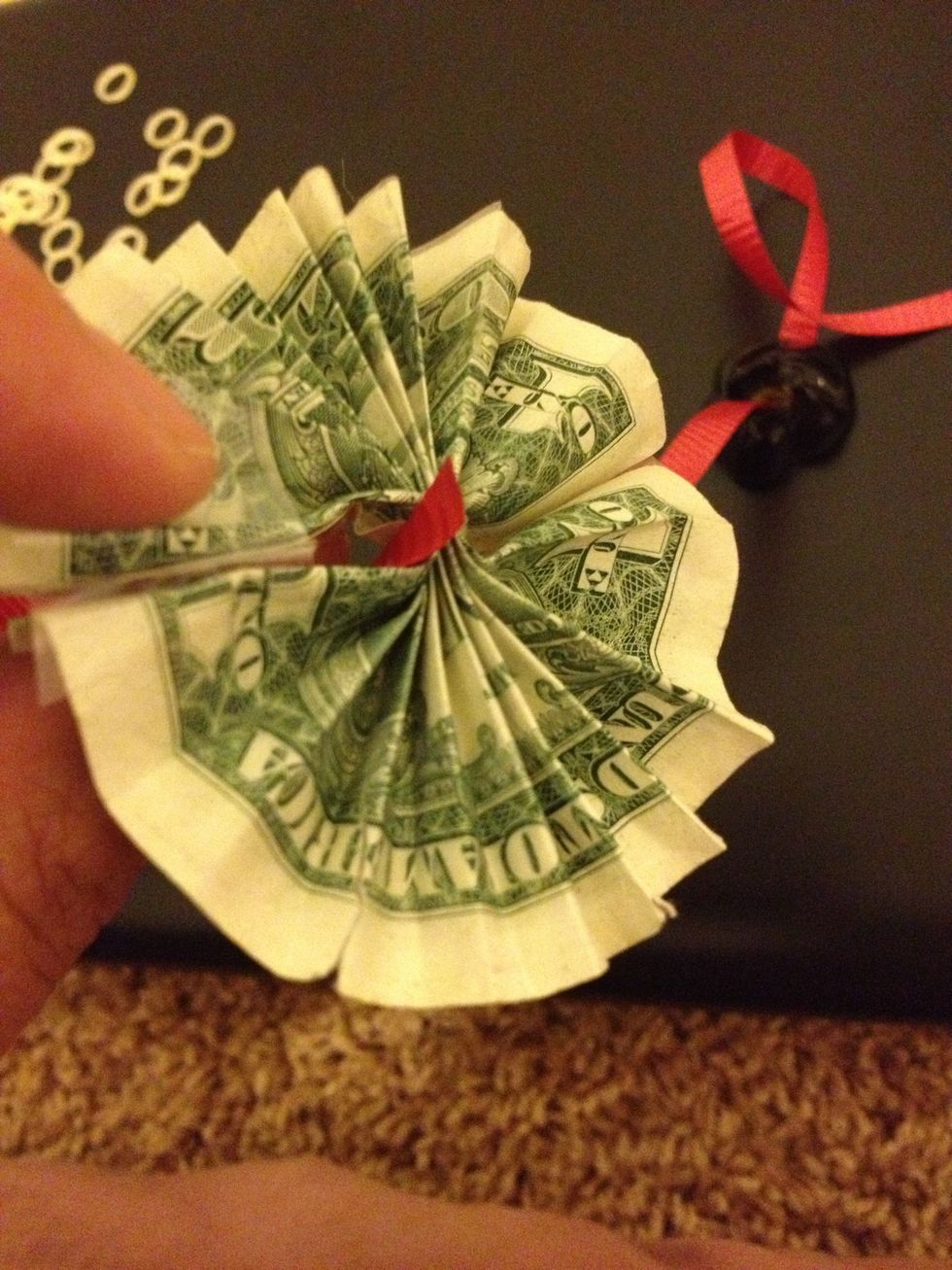 Then through small opening add your flower make sure to add 3 or 4 dollars between beads to give it more of a lei kind of look rather then a beads necklace.