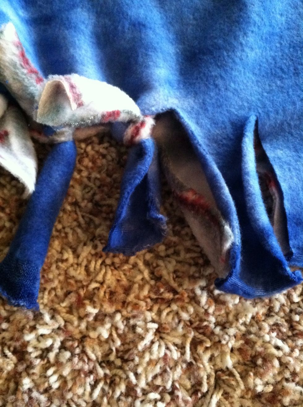 Then tie the two different blankets together all the way down