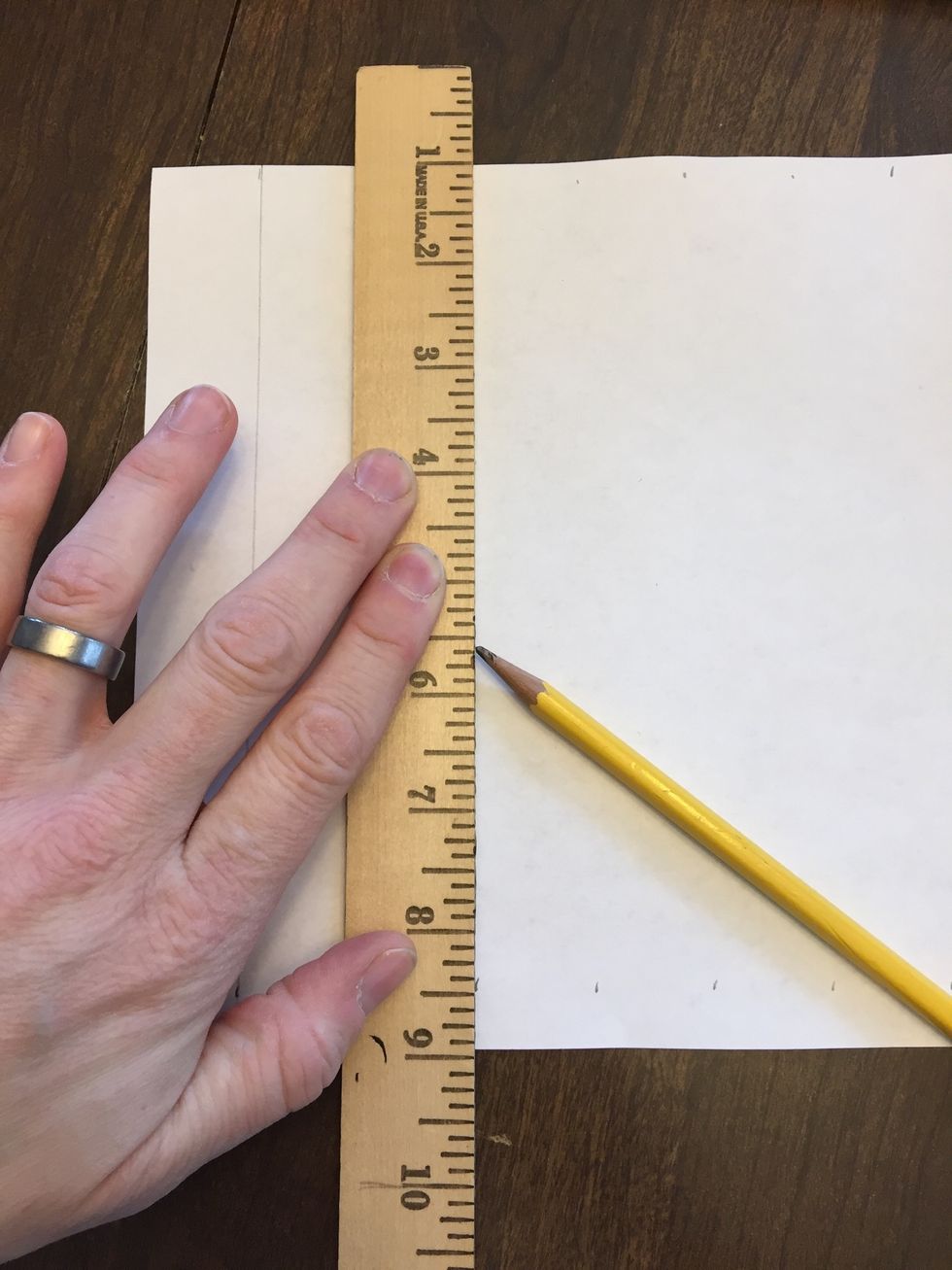 Then turn the ruler so that it crosses from top to bottom and align it with the first marks on the top and the bottom. Draw a light line along the straight edge of the ruler connecting them.
