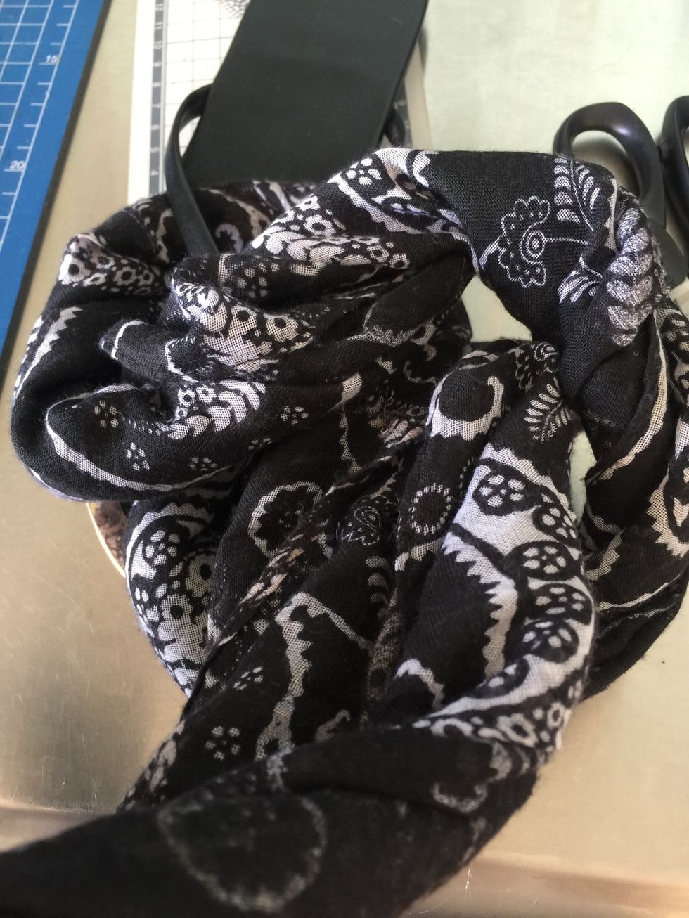 then twisting the scarf to make clear how it will go along the strips of the flip flop