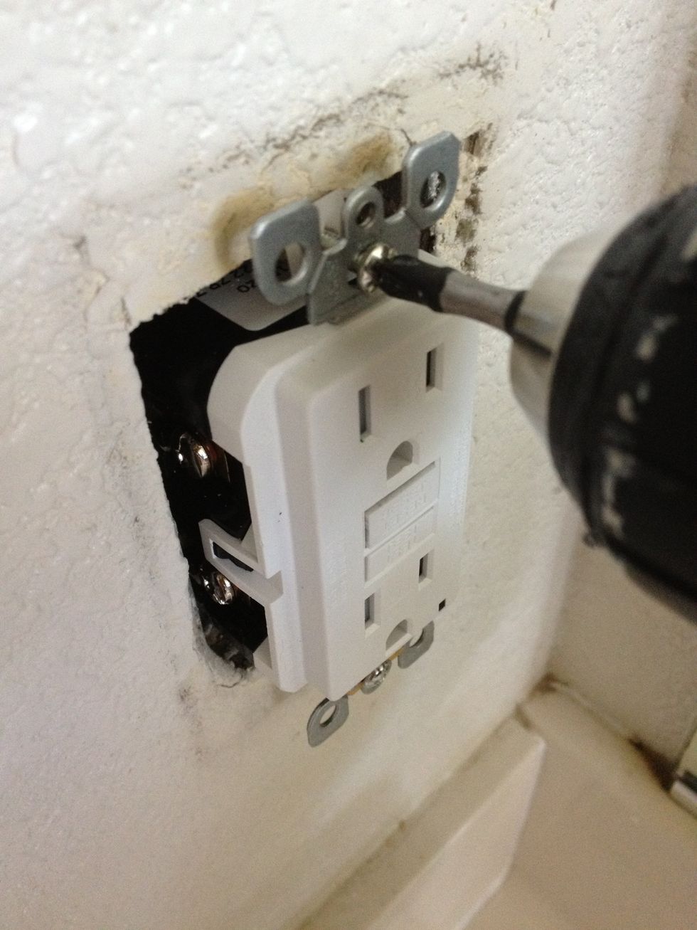 Then use your Phillips screwdriver to anchor the outlet to the J-box, both top and bottom.