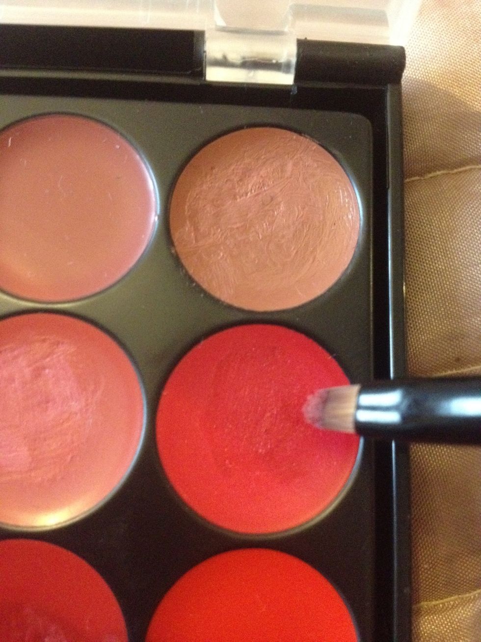 Then using a red from the palette to add gloss and definition with the finer lip brush