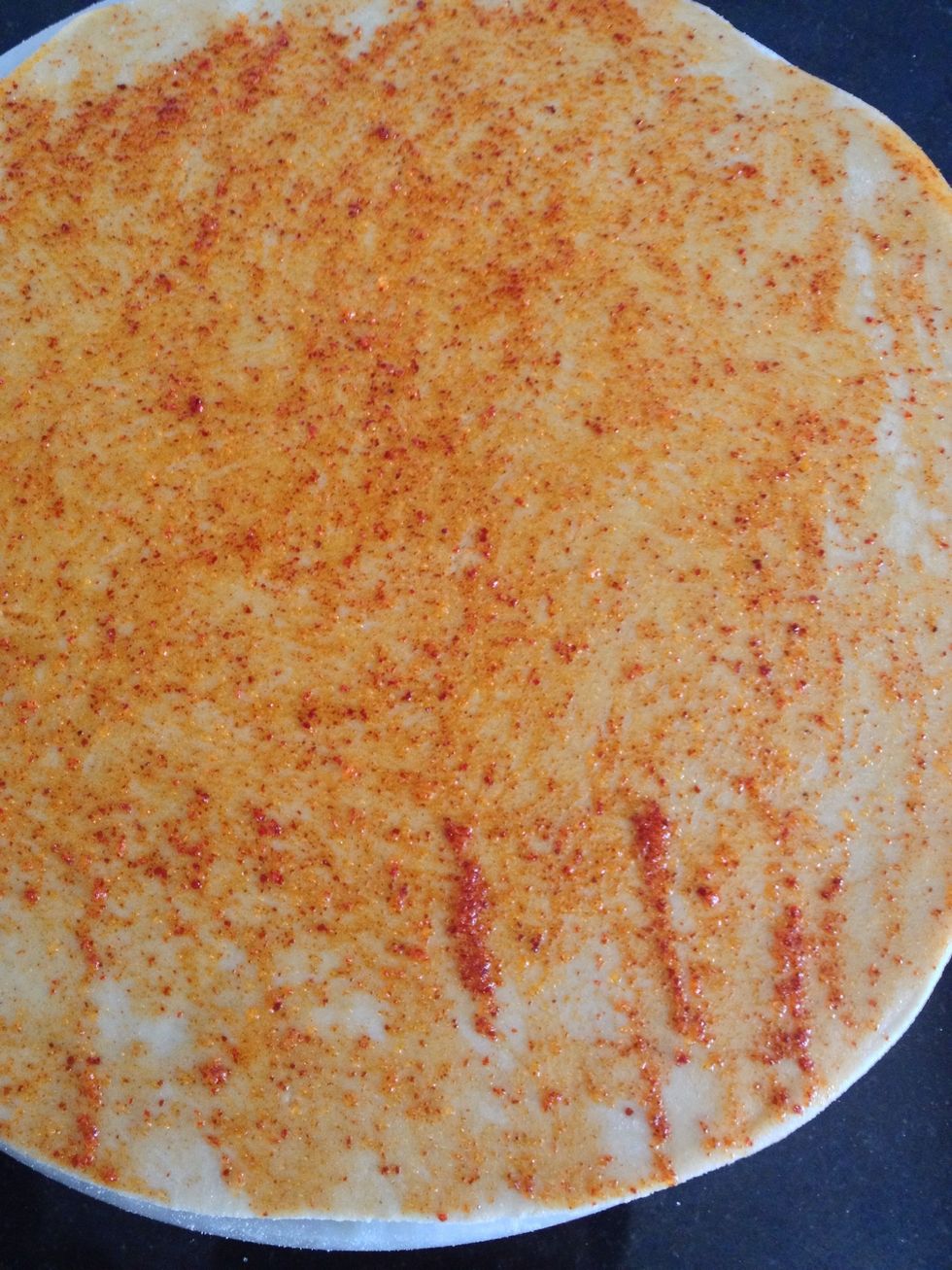 Then using a spoon or hand spread all over the rolled dough .