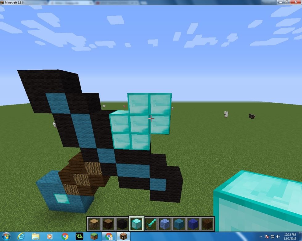 Then we want tot start the main part of the sword. You want to take you Diamond Blocks and make a square first then continue putting three blocks on the sides as you see in the picture.