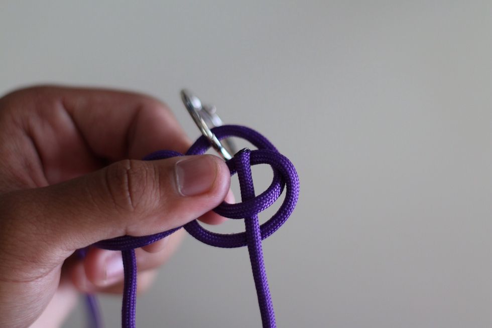 Then weave the cord that's closest to you through the 2 loops like so in the picture above.