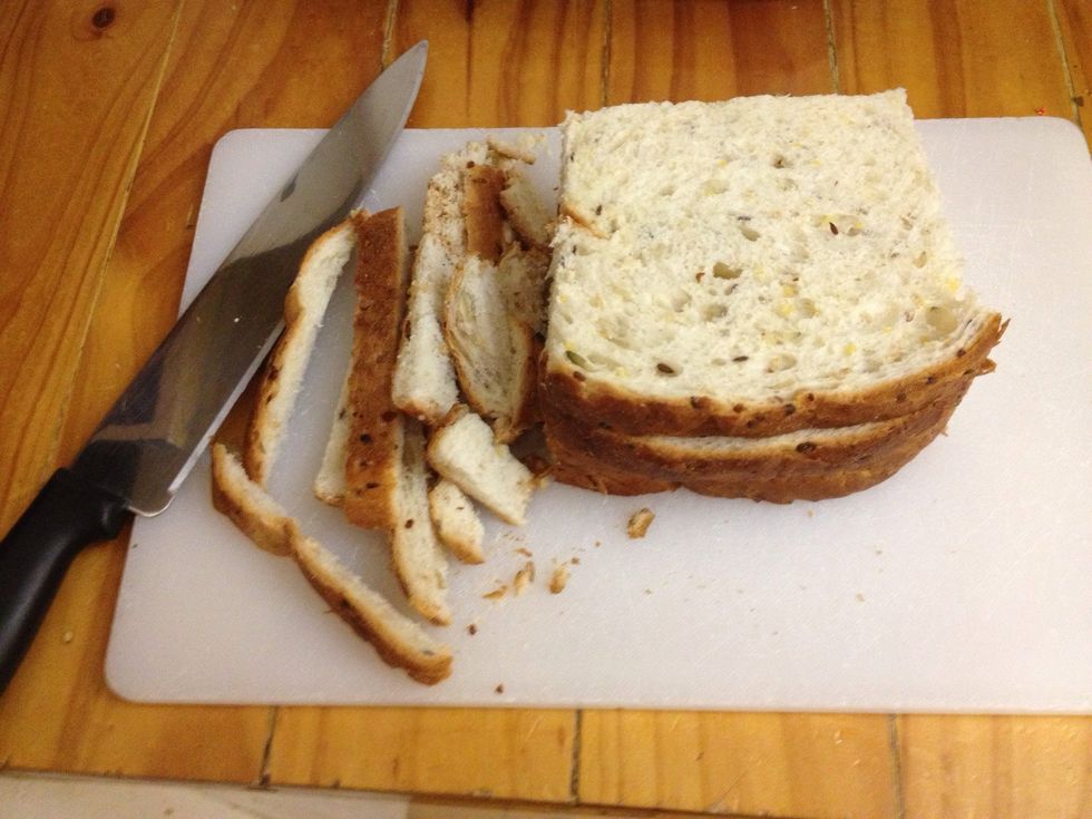 Then with a nice sharp knife, cut the crusts off each slice. Don't throw the crusts away as we'll be using them later. You don't need to be too precise either.