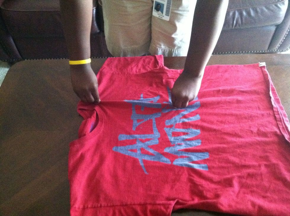 Then with your right hand pinch the shirt directly beside your left hand at the top of the shirt.