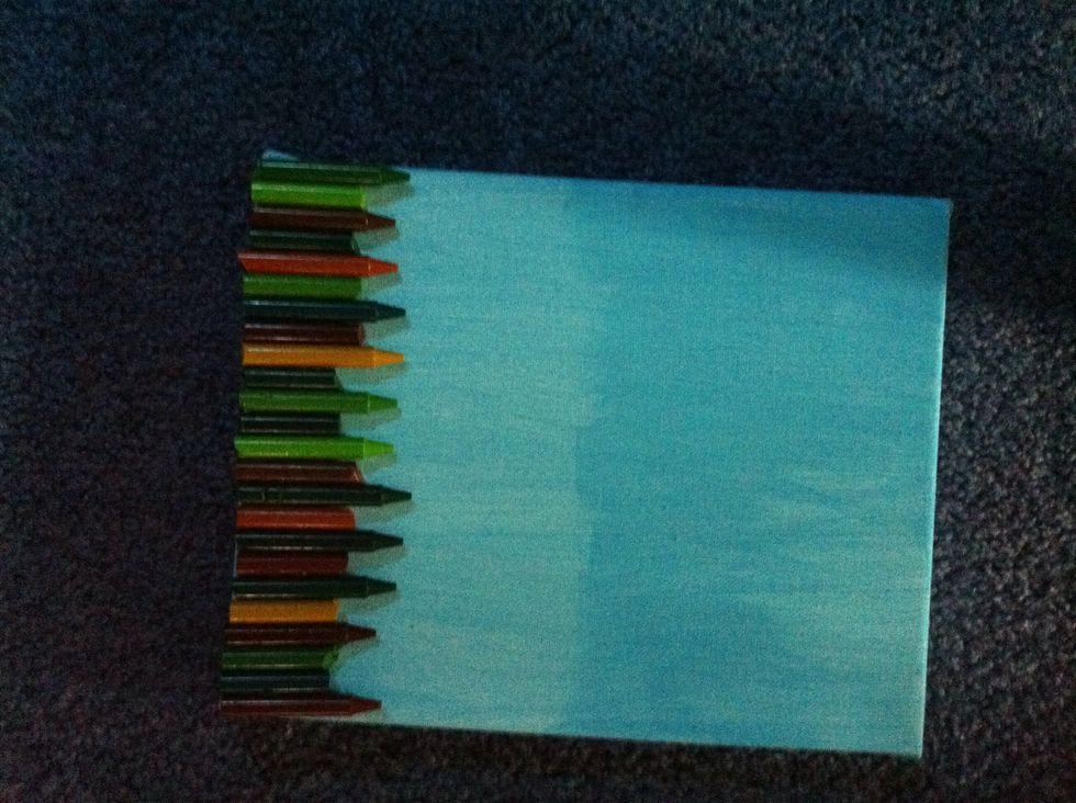 Then you are going to hot glue your crayons to canvas like this.