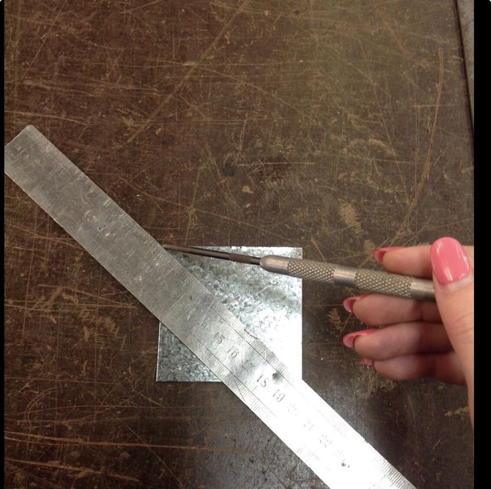 Then you find the middle of the metal by drawing two diagonal lines