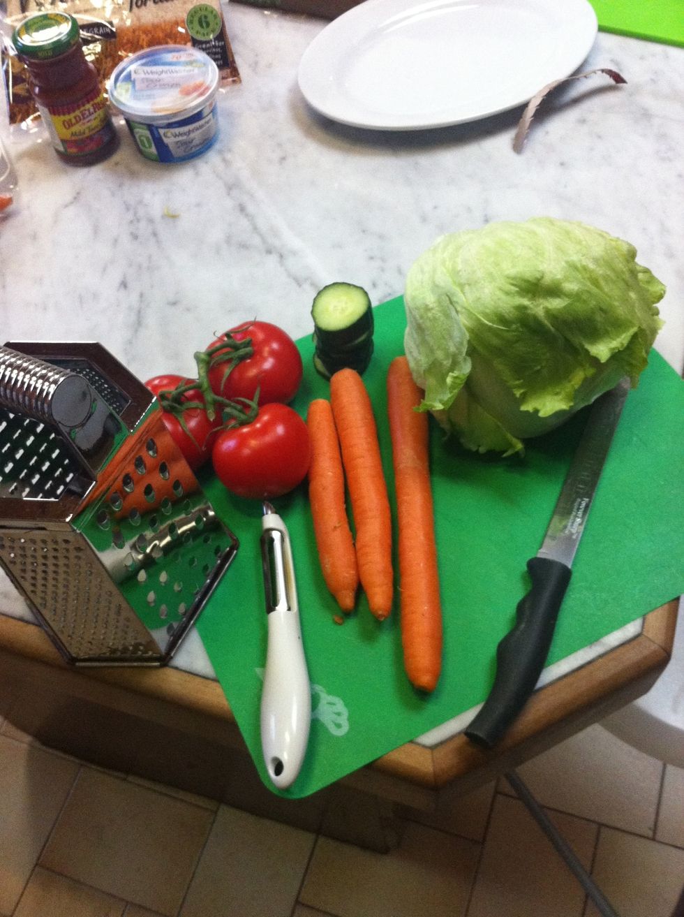 Then you need to peel and grate your carrots, cut up your tomatoes and cucumber and peel the lettuce