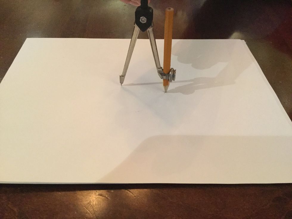 Then you need to put the pencil end of the compass on the paper.