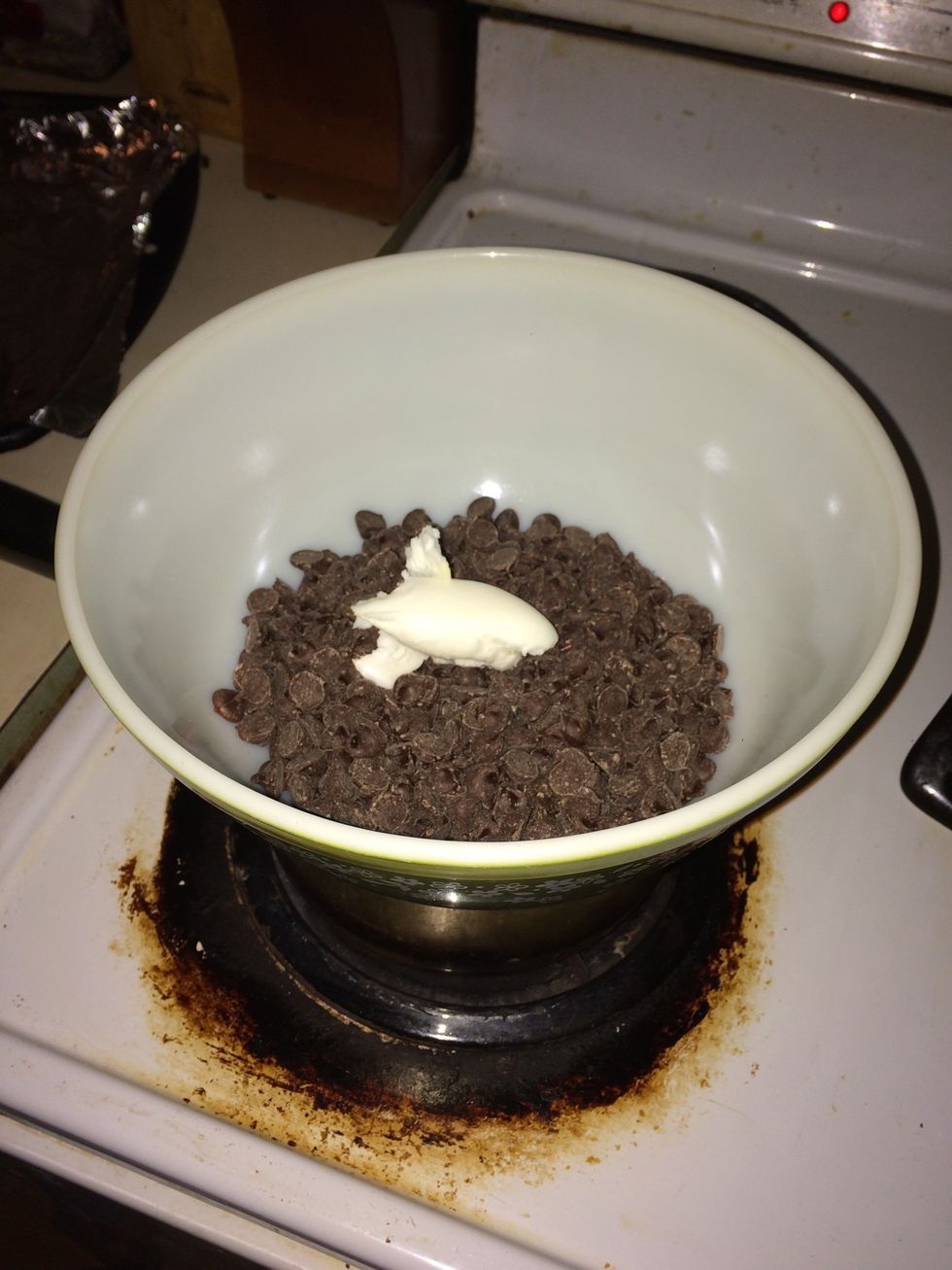 Then you pour your chocolate chips into a bowl over a pot of hot water and let them melt but don't forget to add your shortening so it doesn't stick .