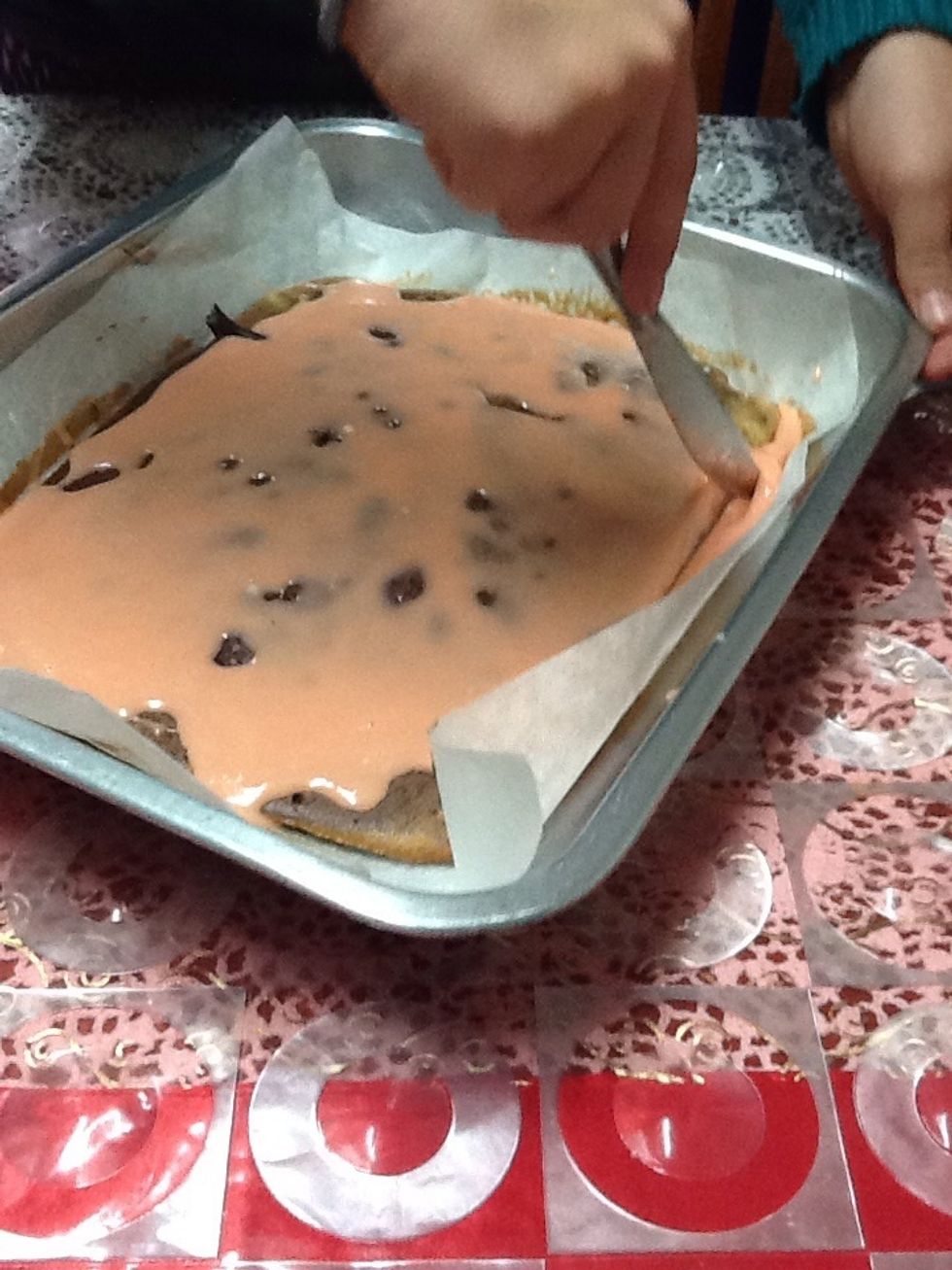 Then you should get a knife and spread it around the cake.