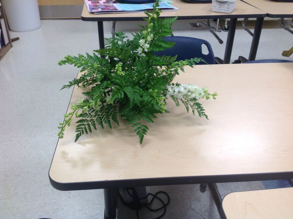 Then you take larkspur and have it stick out of the top, sides, and the front. You can take more larkspur and use it fill in.