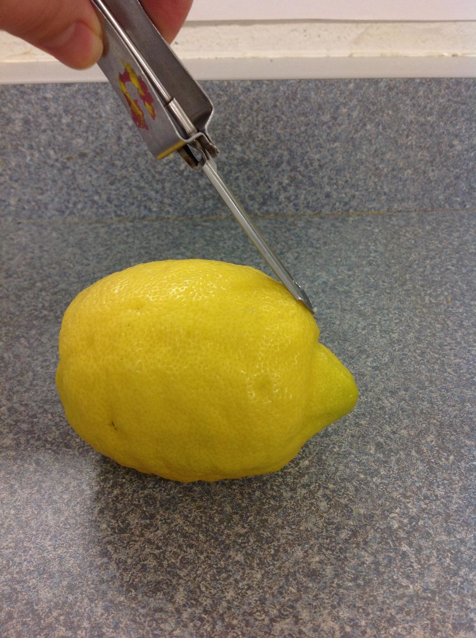Then, you take your vegetable peeler, and scrape lines down the sides of your lemon, all the way around it.