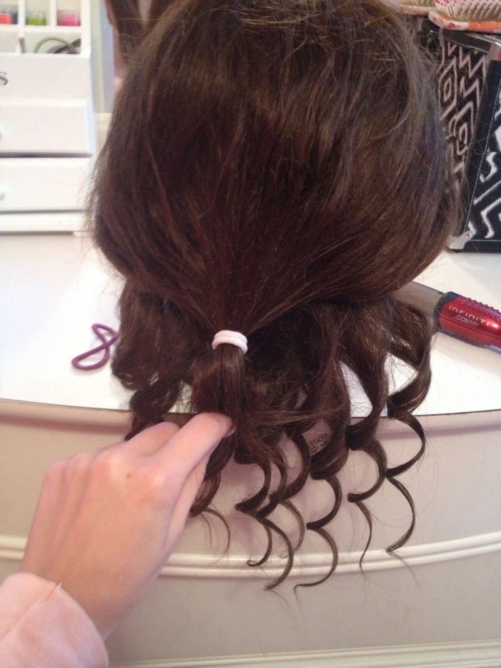 Then you untie the top section. Catch it in your hand so it doesn't tangle with the already curled pieces of hair.