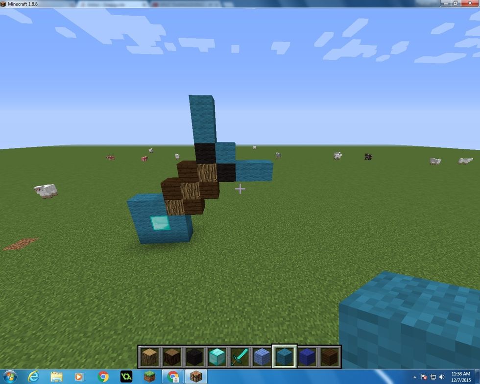 Then you want to take 5 Cyan Wool Blocks and 2 Black Wool Blocks and make a bow and arrow shape.