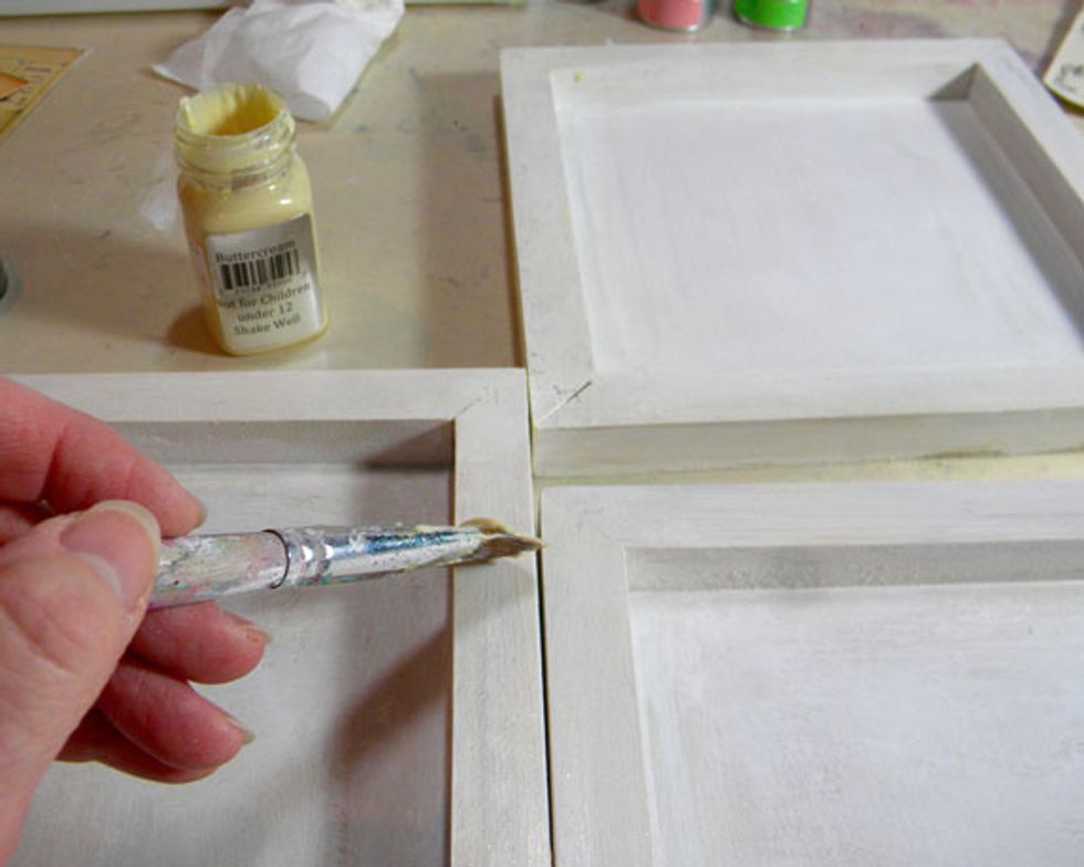 There are a few steps that I take that don't show up in the end. This is one of them. I'm showing you anyway because it's about the process.  Paint a coat of Buttercream Sorbet on each canvas.