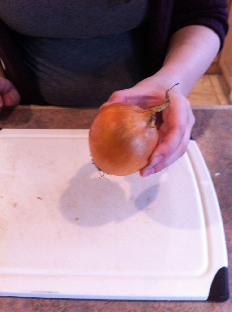 There are two ends of an onion: the root and the stalk.  The root end grows out of the dirt, stalk end is the green plant.  Slice off the stalk end approx. 1 inch so it can stand!