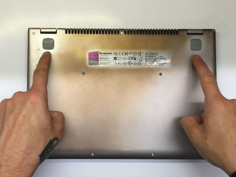 There is a screw under each of the two 'feet' in the top corners, we will remove these next.