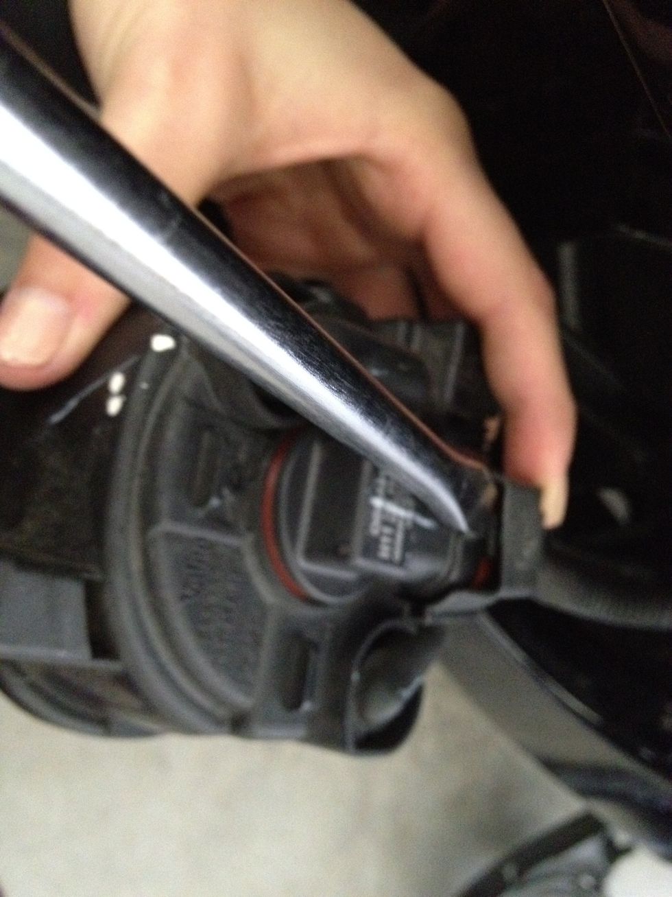 There is a small clip holding the light and wiring together so we need to release the clip with our Flathead screwdriver. Then once it is released, the socket should slide right off.