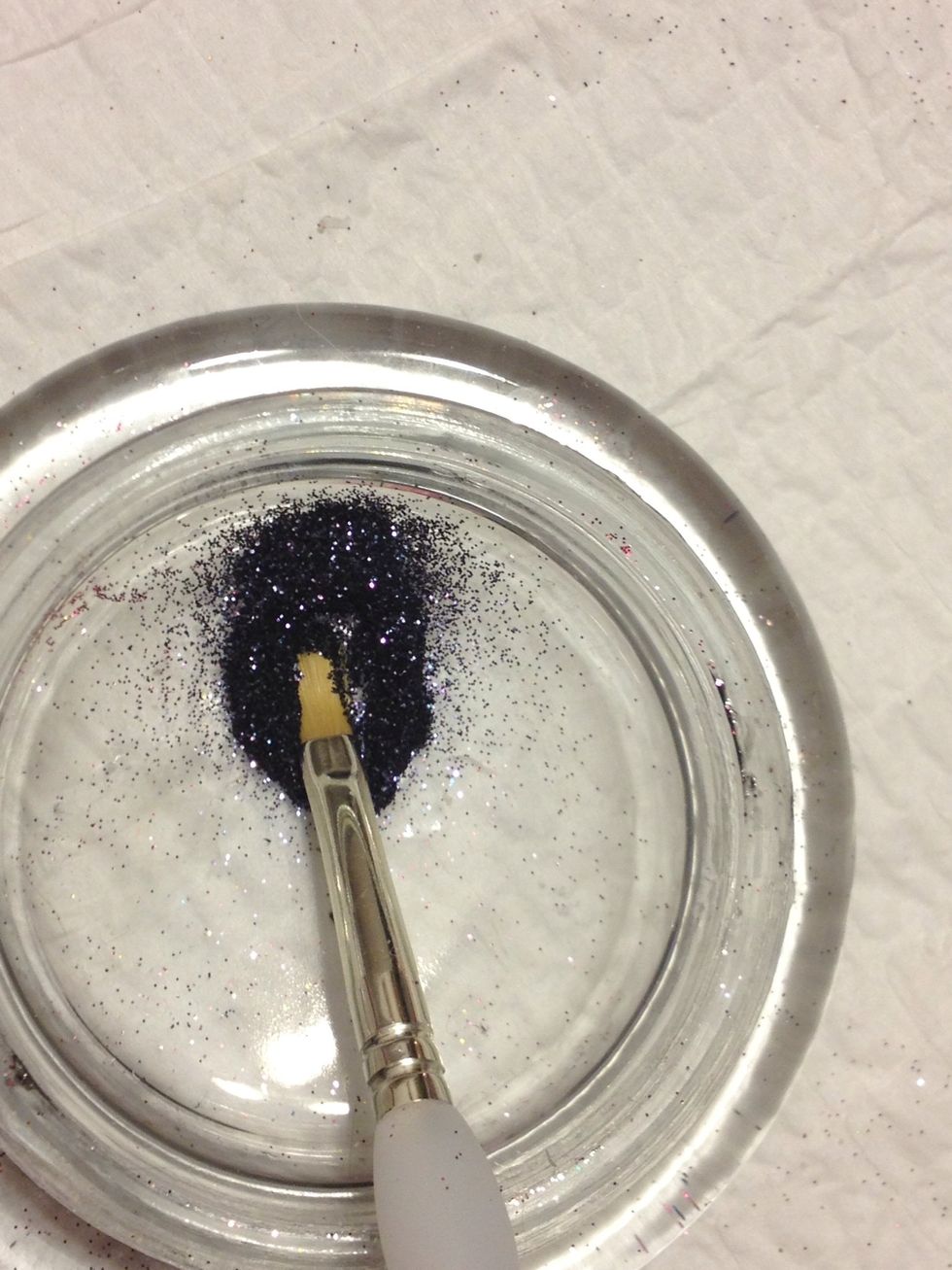 There is a sticky residue on your nail and this is what makes the glitter stick ... Take some on the tip of your brush.